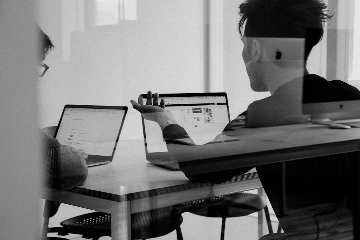 Two salespeople reviewing buying signals on a laptop in a small office