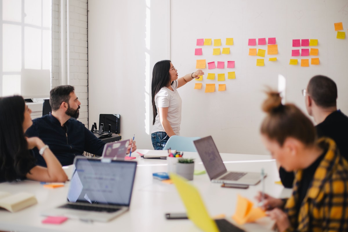 Small team running a short weekly goal check-in around a table